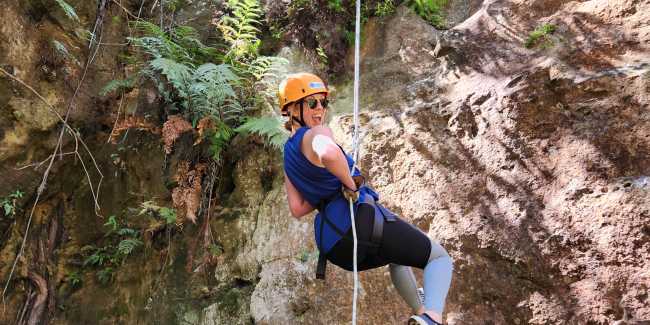Blue Mountains abseiling: a climber descends a sandstone cliff face on rope.